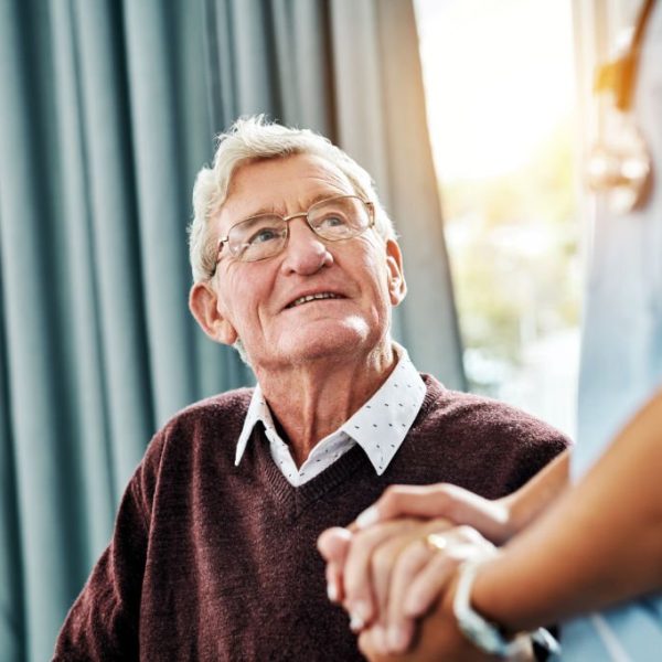 Cropped shot of a nurse holding hands with a senior patient