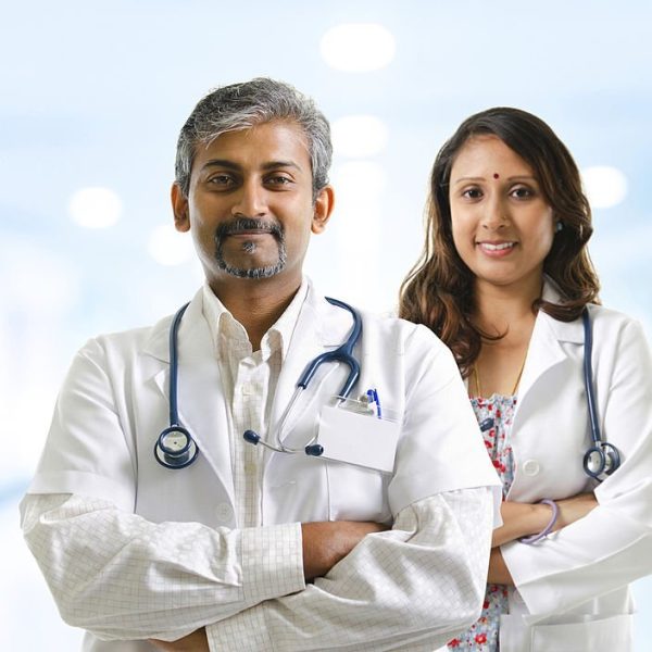 Indian doctors or medical tem crossed arms standing, hospital background